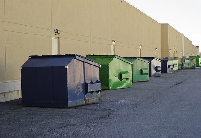 tilted front-load dumpsters being emptied by waste management workers in Bristol